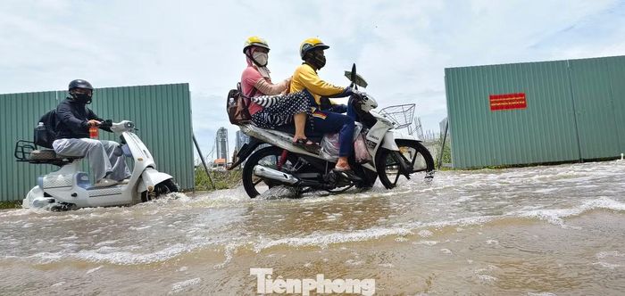 Chị Tuyết Nhung (34 tuổi, ngụ phường Bình Trưng) cho biết thường xuyên đi trên con đường Lương Định Của. Mấy ngày nay, đường này ngập sâu vì mưa liên tục đã khiến xe bị hư hỏng nên hôm nay chị phải gọi xe công nghệ đi làm. Ảnh: Khoa Nam.
