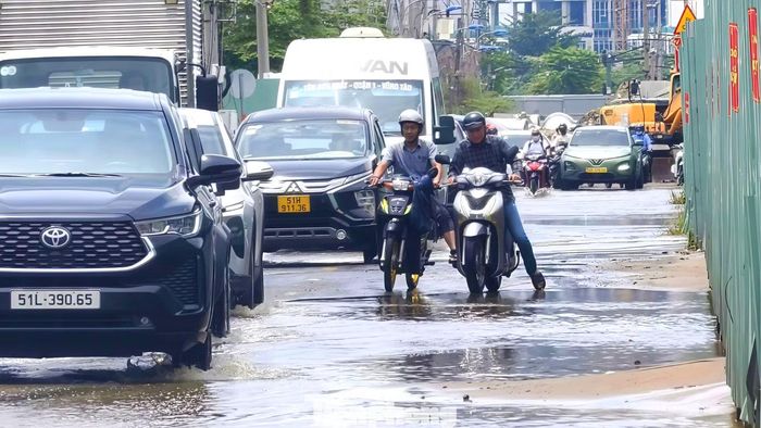 Nhiều xe bị tắt máy khi cố gắng chạy qua các đoạn ngập sâu nên phải nhờ trợ giúp của những người đi khác. Ảnh: Khoa Nam.