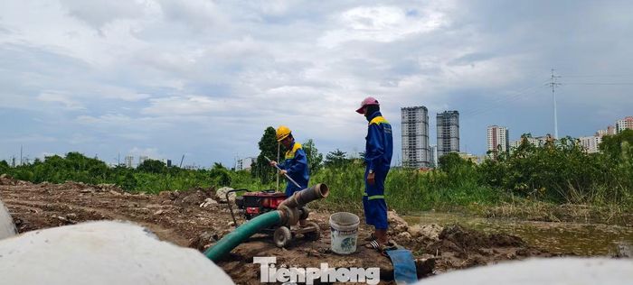Tại khu vực công trường gần đó, công nhân hối hả tiến hành lắp đặt và vận hành 3 máy bơm, hút nước để giải cứu tuyến đường Lương Định Của. Ảnh: Khoa Nam.