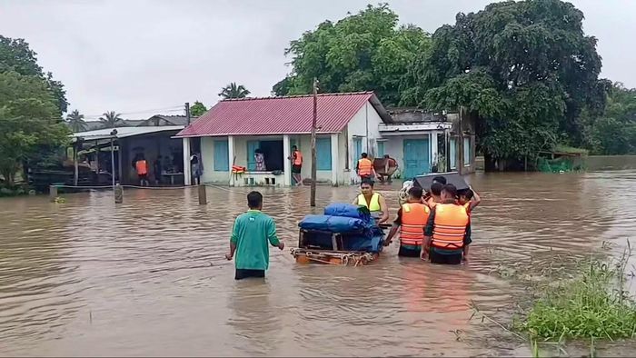 Lực lượng chức năng phường Hàm Thuận hỗ trợ di dời người dân và tài sản đến nơi an toàn.
