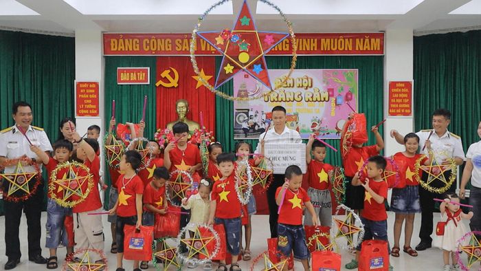 Cán bộ, chiến sĩ đảo Đá Tây tặng quà các cháu thiếu nhi.