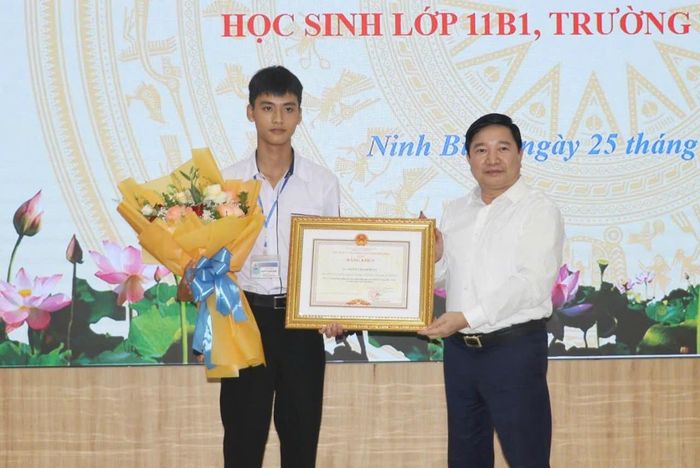 Giám đốc Sở GD-ĐT Ninh Bình Nguyễn Tiến Dũng trao bằng khen của Chủ tịch UBND tỉnh cho em Nguyễn Mạnh Hùng.