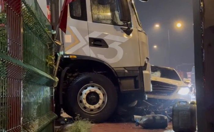 Chiếc Mercedes kéo lê một người đàn ông cùng xe máy lao thẳng lên vỉa hè, rồi đâm mạnh vào 2 ô tô tải của một cửa hàng mua bán xe gần đó mới dừng lại. Ảnh: TK