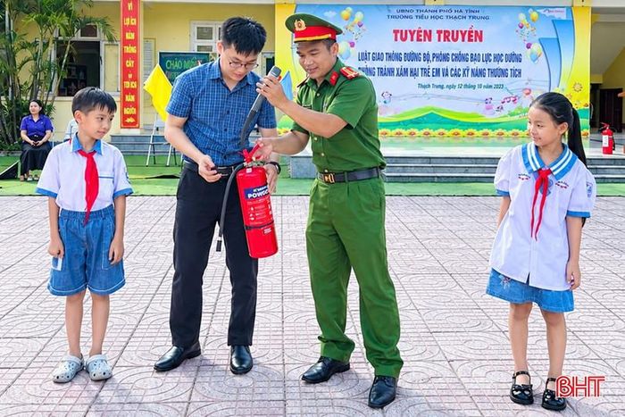 Công an Phường Trần Phú hướng dẫn học sinh Trường Tiểu học Quang Trung cách sử dụng bình chữa cháy bằng tay.