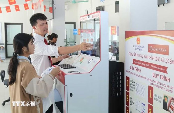 Cán bộ Agribank tỉnh Lạng Sơn hướng dẫn người dân thực hiện thủ tục hành chính qua “Trạm dịch vụ công số” xã Lộc Bình. (Ảnh: Quang Duy/TTXVN)