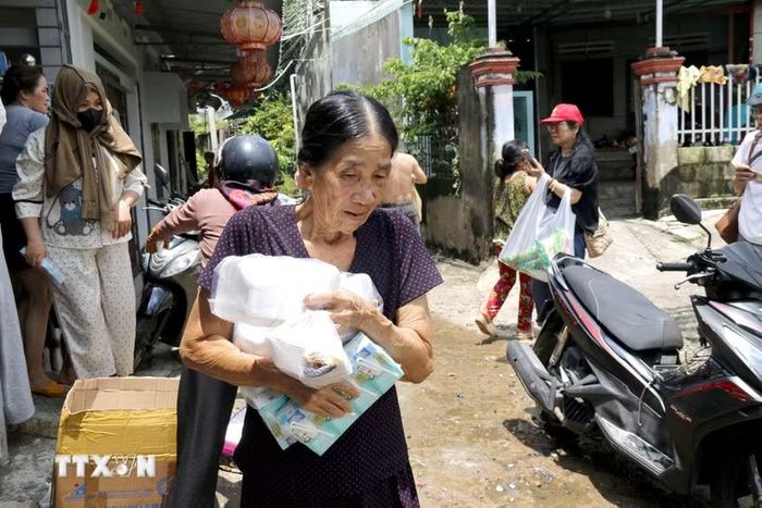 Sự hỗ trợ kịp thời đã góp phần đáp ứng nhu cầu trước mắt của người dân phải di dời tránh ngập lụt. (Ảnh: Hồng Hiếu/TTXVN)
