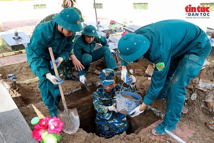 Cán bộ, chiến sĩ lực lượng dân quân xã Đông Anh khai quật mộ liệt sĩ chưa xác định được danh tính.