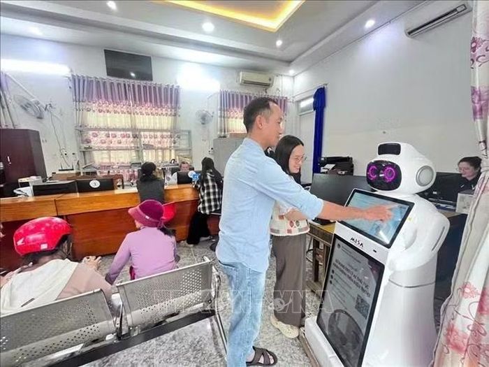 Robot thông minh tích hợp AI hỗ trợ người dân tra cứu thủ tục và lấy số thứ tự tại Trung tâm Phục vụ hành chính công xã Vạn Thắng. Ảnh TTXVN phát