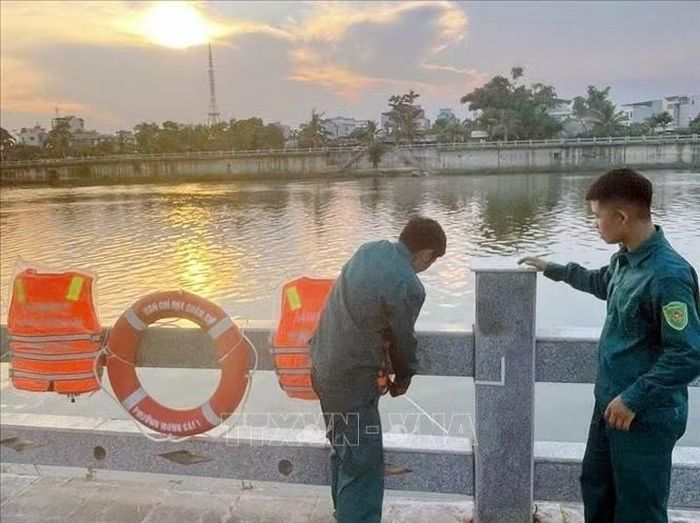 Ban Chỉ huy Quân sự phường Móng Cái 1 tiến hành treo áo phao, phao cứu sinh dọc sông Ka Long. Ảnh: TTXVN phát