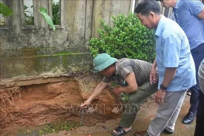Lực lượng chức năng kiểm tra, đánh giá tại hố sụt lún tại xã Hiếu Giang. Ảnh: TTXVN phát
