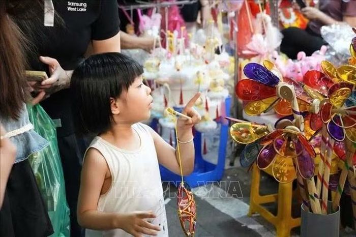 Các em nhỏ ngắm các đồ chơi truyền thống tại khu vực phố cổ Hà Nội.