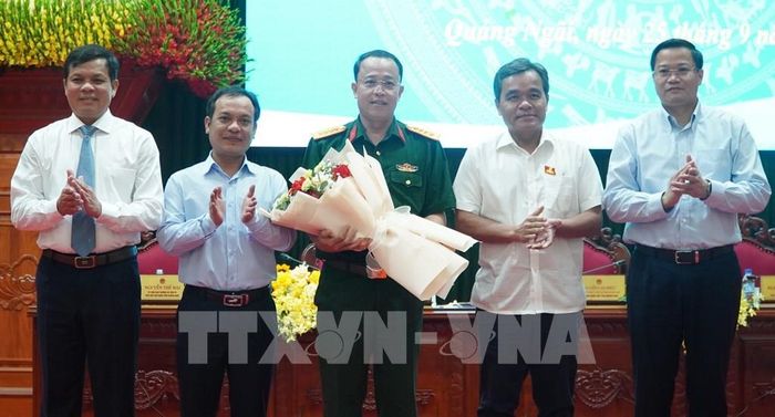 Lãnh đạo tỉnh Quảng Ngãi tặng hoa chúc mừng Đại tá Trần Hữu Ích, Chỉ huy trưởng Bộ Chỉ huy Quân sự tỉnh, được bầu bổ sung làm Ủy viên UBND tỉnh. Ảnh: Dư Toán - TTXVN