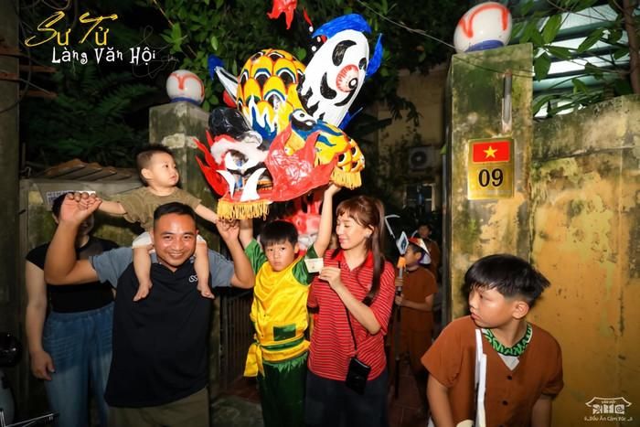 Từ những em bé còn được người lớn bế trên tay đến các bạn nhỏ đã có thể tự mình chạy nhảy, tất cả đều chăm chú hướng mắt về phía đoàn múa lân. Tiếng trống lúc rộn ràng, lúc dồn dập hòa cùng tiếng reo hò, tiếng cười khiến sân đình trở thành một không gian đầy sức sống.