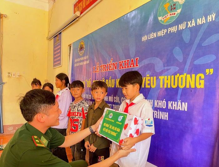 Thiếu tá Đỗ Xuân Điềm, Chính trị viên Đồn Biên phòng Nậm Nhừ, trao tặng quà và biểu trưng nhận đỡ đầu, tiếp thêm động lực cho các em nhỏ có hoàn cảnh khó khăn ngay những ngày đầu năm học mới. 