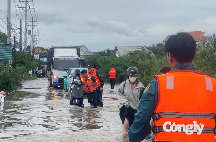 Cán bộ, chiến sĩ cảnh sát cơ động hỗ trợ người dân di chuyển ra khỏi khu vực ngập lụt.
