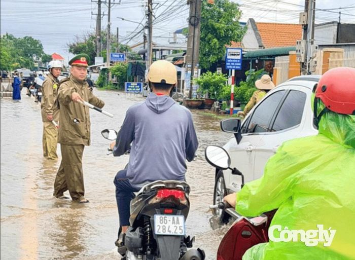 Lực lượng Công an xã Hàm Liêm điều tiết, phân luồng giao thông tại khu vực bị ảnh hưởng do mưa lũ.