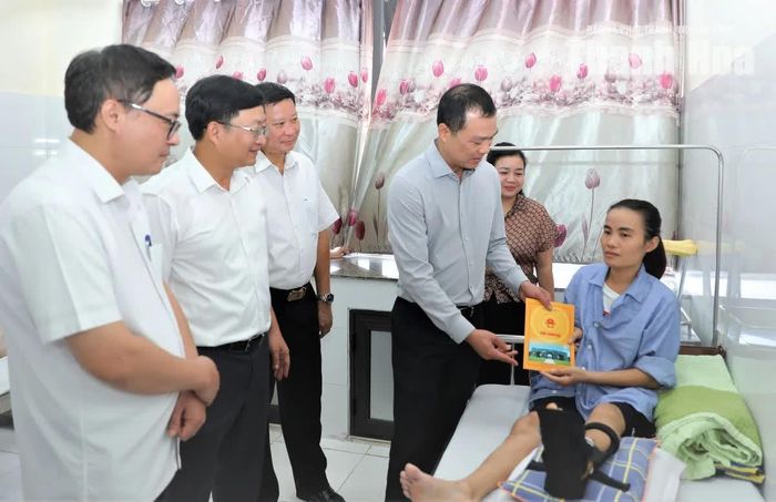 Chủ tịch UBND tỉnh Tô Anh Dũng trao quà động viên chị Thu yên tâm điều trị, sớm phục hồi sức khỏe.