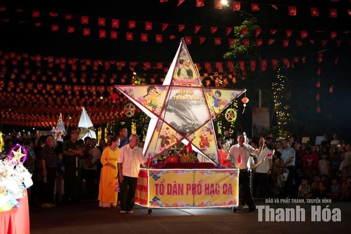 Mô hình đèn ông sao cỡ lớn của tổ dân phố Hạc Oa diễu hành qua khu vực sân khấu.