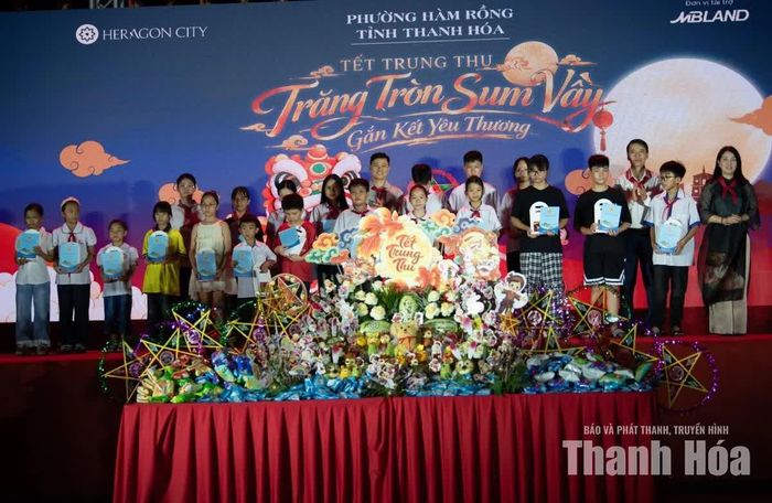 Đại diện cấp ủy, chính quyền địa phương và đơn vị tài trợ trao quà cho các em học sinh có hoàn cảnh khó khăn vươn lên trong học tập.