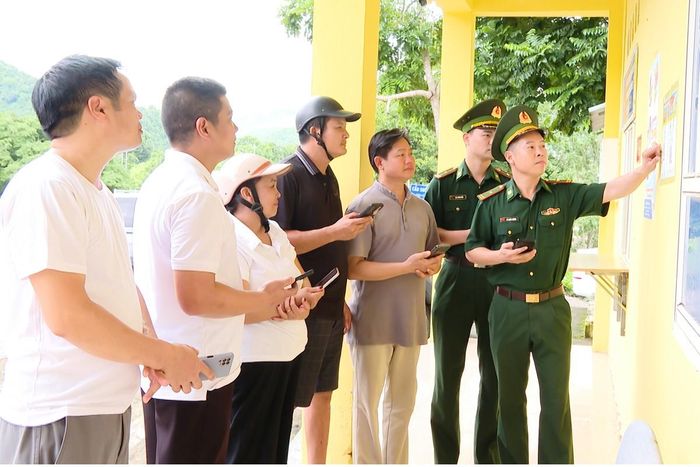 Cán bộ Đồn Biên phòng cửa khẩu Tén Tằn hướng dẫn người dân sử dụng tiện ích số, làm thủ tục qua lại biên giới và quét mã QR tiếp nhận tin báo, tố giác tội phạm tại Trạm cửa khẩu Tén Tằn. Ảnh: Nguyễn Thuấn