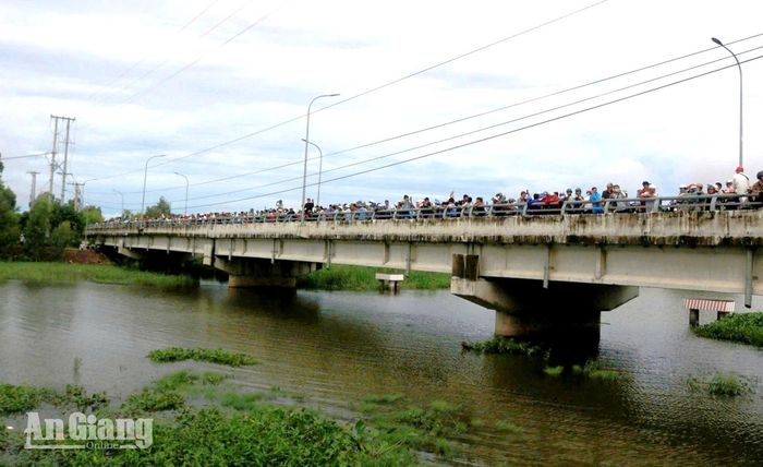 Người dân theo dõi việc vận hành mở cống Tha La.