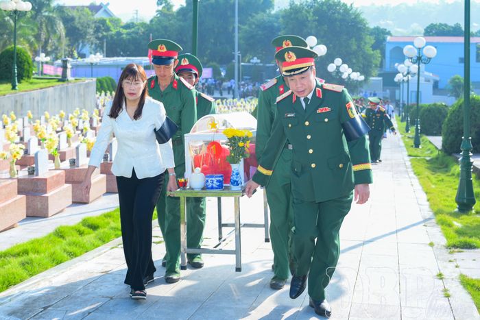 Đại biểu thực hiện nghi thức đưa hài cốt liệt sĩ đến nơi an táng.