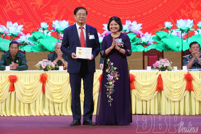Bà Trần Thị Dung, Phó Chủ tịch Thường trực Hội Bảo trợ người khuyết tật Việt Nam trao Kỷ niệm chương “Vì sự nghiệp bảo trợ người khuyết tật và trẻ mồ côi Việt Nam” cho ông Lò Văn Mừng.