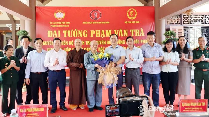 Phó Bí thư Đảng ủy, Chủ tịch UBND phường Long Thành Lê Hoàng Sơn tặng hoa cảm ơn Đại tướng Phạm Văn Trà. Ảnh: Nguyệt Hà