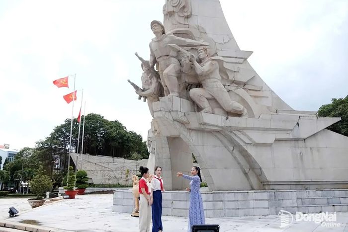 Chị Trần Thị Minh Nhật giới thiệu đến hai MC và khán giả "Khám phá Đồng Nai" về những giá trị, dấu mốc gắn với Di tích lịch sử cấp quốc gia Địa điểm Chiến thắng Đồng Xoài. Ảnh: Tiến Dũng