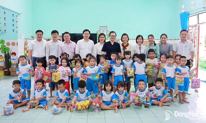 Đoàn kiểm tra của Bộ Giáo dục và Đào tạo, Sở Giáo dục và Đào tạo thành phố Đồng Nai, lãnh đạo phường Trảng Bom chụp hình cùng các em Trường mầm non Hoa Mai. Ảnh: Thành Toàn