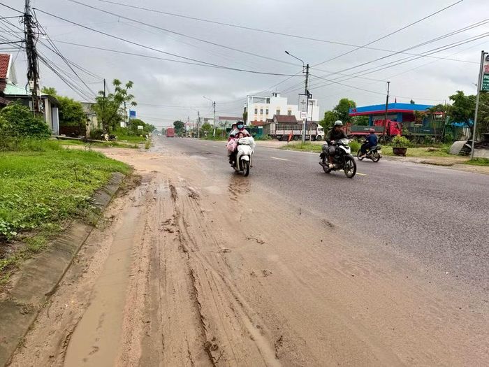  Bùn đất phủ trên mặt đường QL 19, đoạn qua thôn Bình Nghi, xã Tây Sơn. Ảnh: N.C 