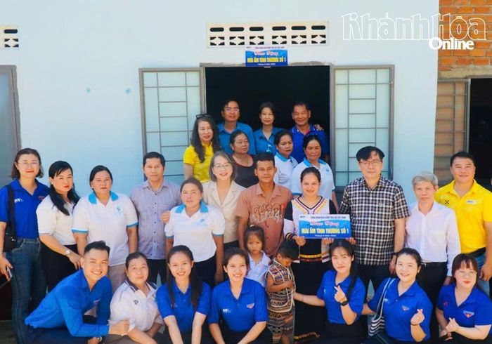Bà Cao Thị Thảo (người cầm bảng tượng trưng) vui mừng khi có căn nhà mới.