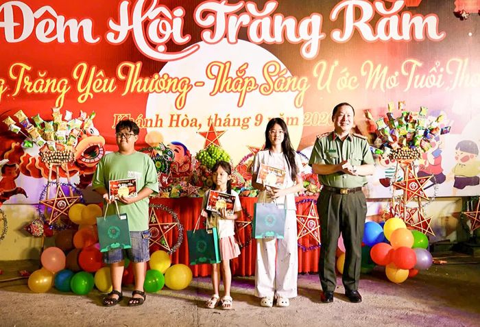 Đại tá Nguyễn Quân trao học bổng cho thiếu nhi vượt khó vươn lên học tốt.