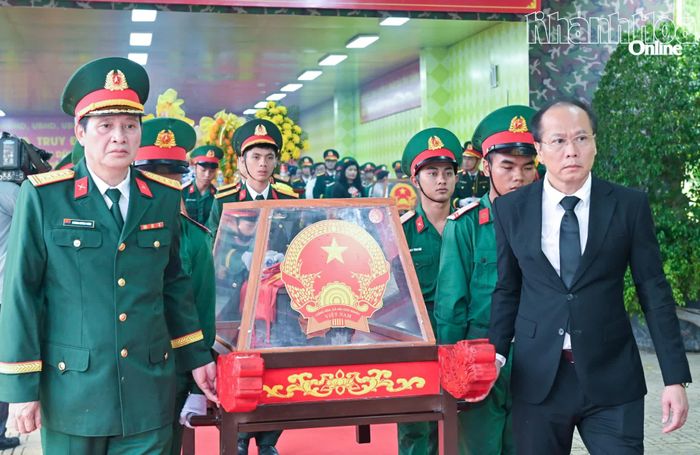 Đồng chí Nguyễn Khắc Hà, các đại biểu cùng đội tiêu binh di chuyển hài cốt các liệt sĩ đến ô mộ để an táng.