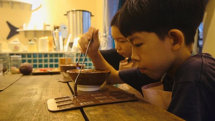 Các em tự tay đổ cacao vào khuôn.