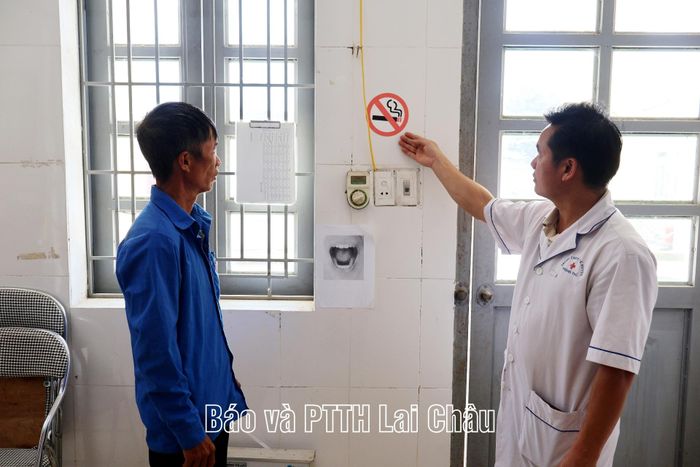 Bác sĩ Trạm Y tế xã Sì Lở Lầu nhắc nhở người nhà bệnh nhân không hút thuốc trong đơn vị.
