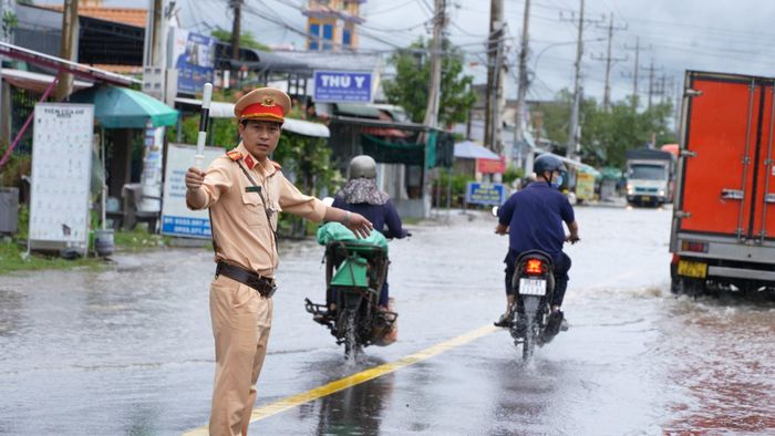 CSGT hỗ trợ người dân qua khu vực ngập nước ở Hàm Thắng