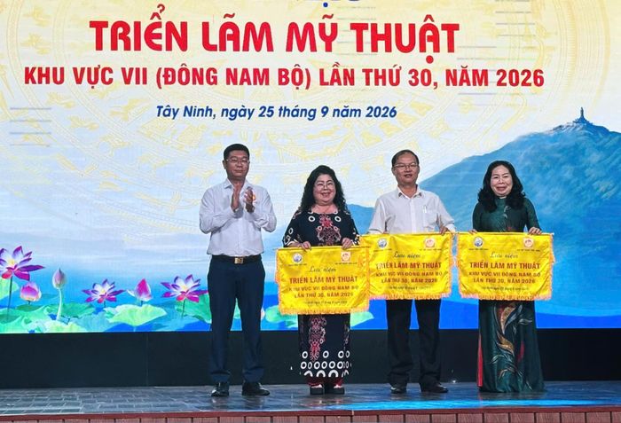 Bà Nguyễn Thị Huyền Diệu, Phó Chủ tịch Hội Văn học Nghệ thuật Lâm Đồng, Tổng Biên tập Tạp chí Văn nghệ Lâm Đồng (thứ 2 từ trái) nhận cờ lưu niệm