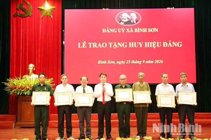 Đồng chí Nguyễn Văn Đoàn, Bí thư Đảng uỷ, Chủ tịch HĐND xã Bình Sơn trao Huy hiệu Đảng cho các đảng viên trong Đảng bộ.