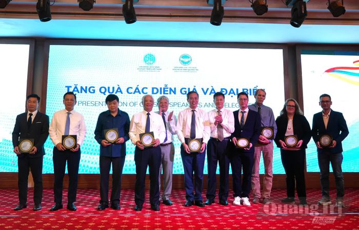 Đồng chí Hà Hùng Cường, Chủ tịch Hội đồng Hòa bình và Phát triển Việt Nam và đồng chí Lương Ngọc Bính, Chủ tịch Liên hiệp các tổ chức hữu nghị tỉnh tặng quà cho các đồng chí lãnh đạo tỉnh, chuyên gia, đối tác nước ngoài và nhà tài trợ tham dự tọa đàm - Ảnh: T.Đ