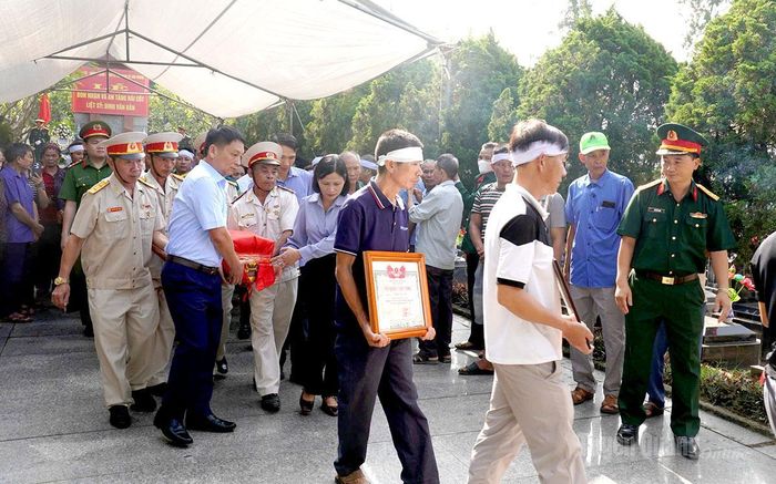 Đại biểu và gia đình thực hiện nghi thức và an táng hài cốt liệt sỹ Đinh Văn Bản.
