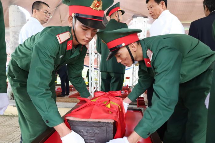 Nâng niu hài cốt các liệt sĩ đặt vào lòng đất mẹ.