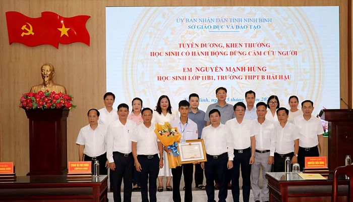 Tuyên dương, khen thưởng em Nguyễn Mạnh Hùng, học sinh lớp 11B1, Trường THPT B Hải Hậu vì đã có hành động dũng cảm cứu hai em nhỏ bị đuối nước trên sông. (Ảnh: BNB).
