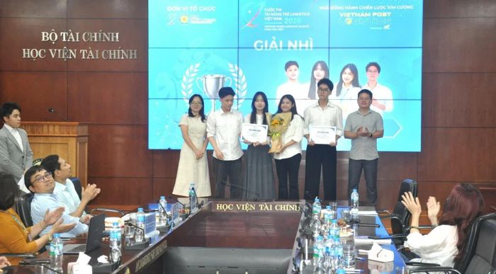TS. Nguyễn Đình Chiến - Phó Trưởng khoa Thuế và Hải quan và TS. Đào Minh Thu - Đại học Điện lực trao giải Nhì cho đội 4sight. Ảnh: Đức Việt.