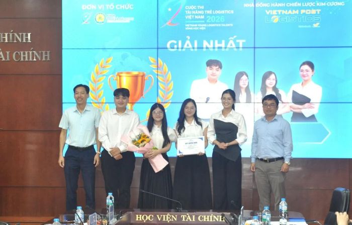 PGS.TS Lê Xuân Trường - Trưởng khoa Thuế và Hải quan (đứng ngoài cùng bên trái) và ông Vũ Hùng Cường-Phó Giám đốc trung tâm giải pháp kho vận, Tổng công ty Bưu điện Việt Nam trao giải Nhất cho Đội Fourfold. Ảnh: Đức Việt.