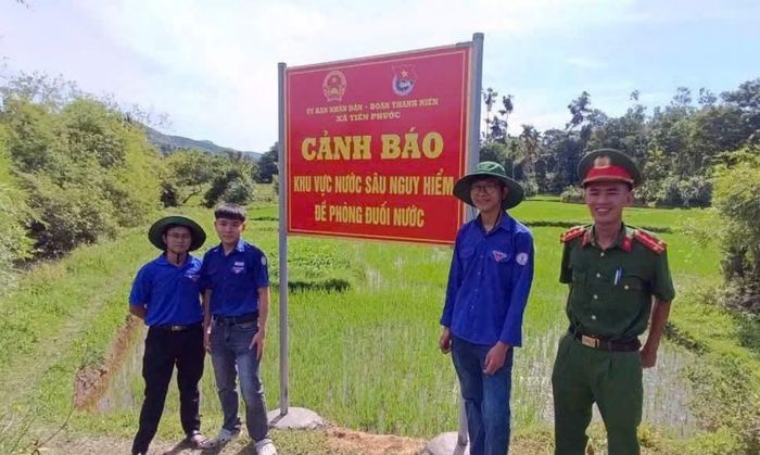 Cán bộ Công an xã Tiên Phước tham gia cắm biển cảnh báo khu vực nước sâu nguy hiểm, đề phòng đuối nước.