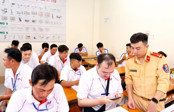 Cán bộ Phòng CSGT hướng dẫn công dân cài đặt, sử dụng ứng dụng VNeTraffic trước khi tham gia kỳ sát hạch.