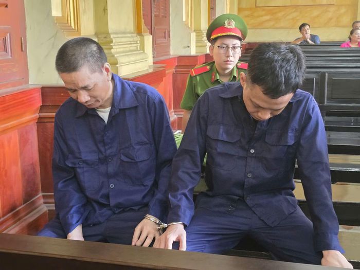 Hai bị cáo Nguyễn Quốc Việt và Thái Xuân Bình tại tòa.