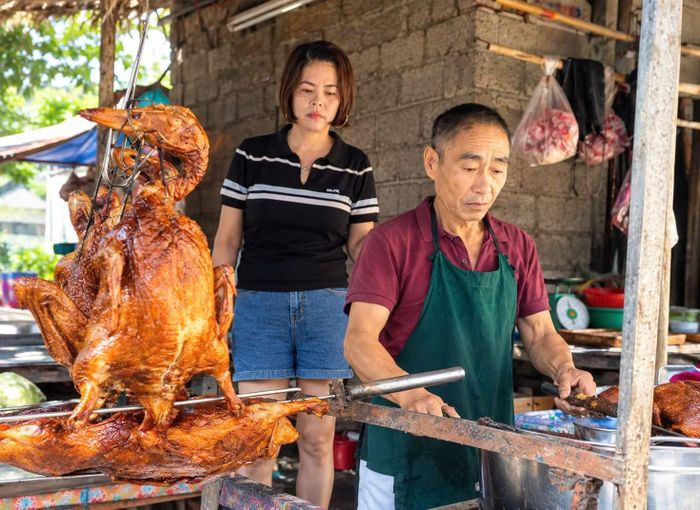 Vợ chồng anh Dương Văn Sơn với cửa hàng bán vịt quay.