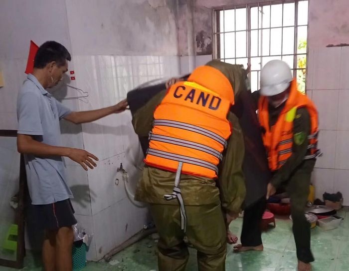 Lực lượng chức năng hỗ trợ người dân bị ảnh hưởng bởi mưa lũ di dời tài sản.